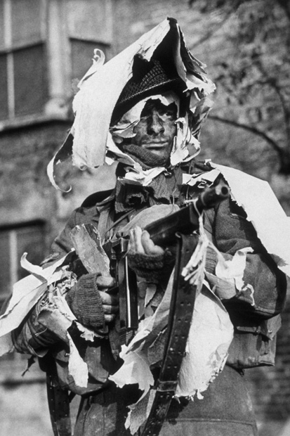 A member of the London Home Guard demonstrates the use of old wallpaper as camouflage (1942)
